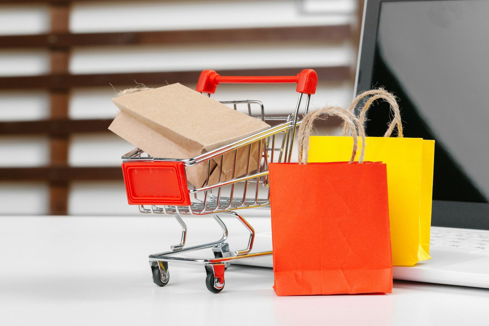 Online shopping concept. Shopping cart, laptop on the desk